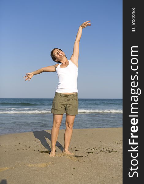 Young girl exercises gymnastics on the beach