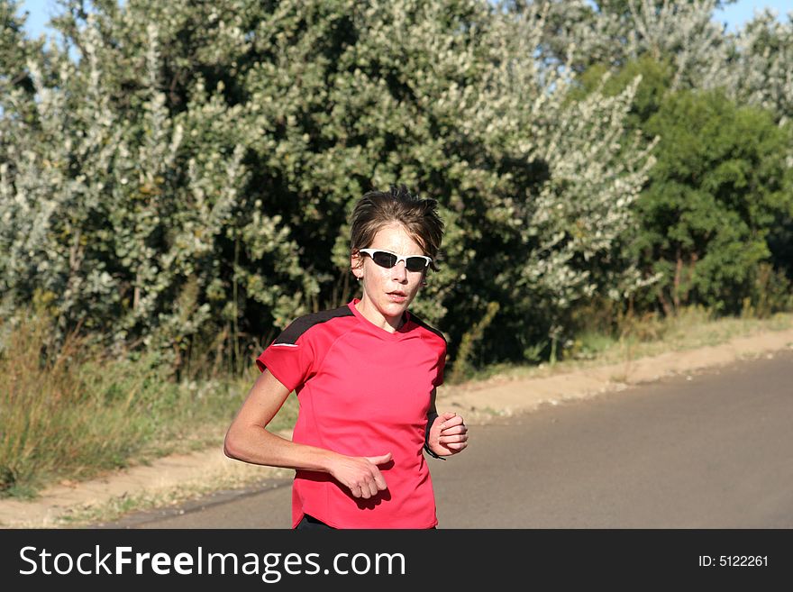 Female athlete in red running for training.