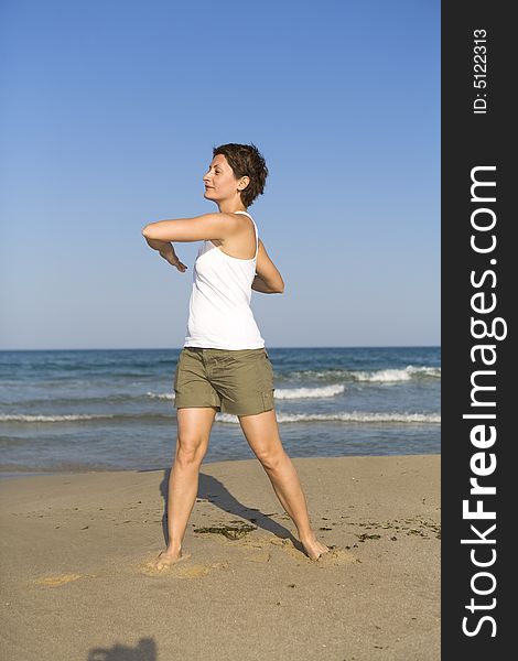 Young girl exercises gymnastics on the beach