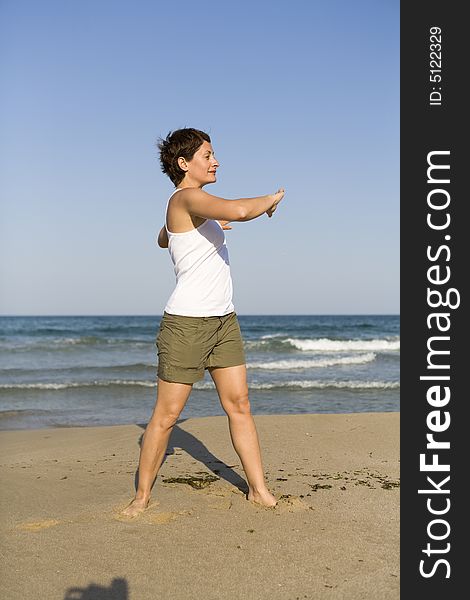 Young girl exercises gymnastics on the beach