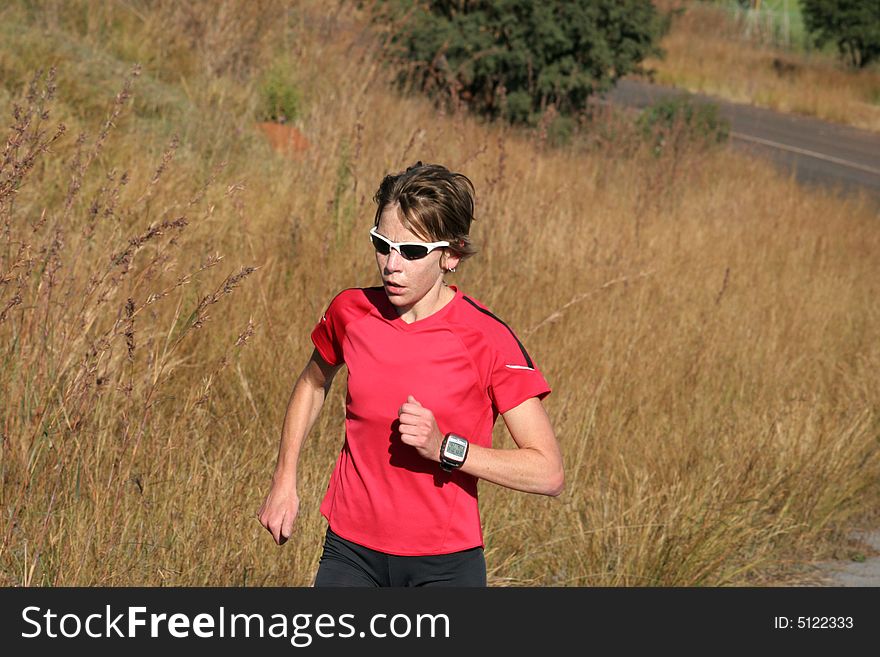 Female athlete in red running for training.