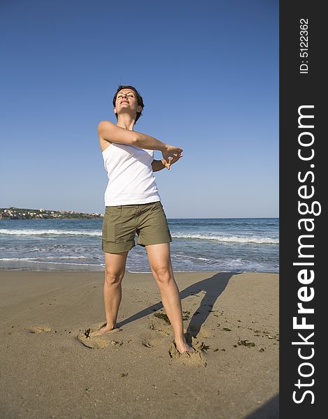 Young girl exercises gymnastics on the beach