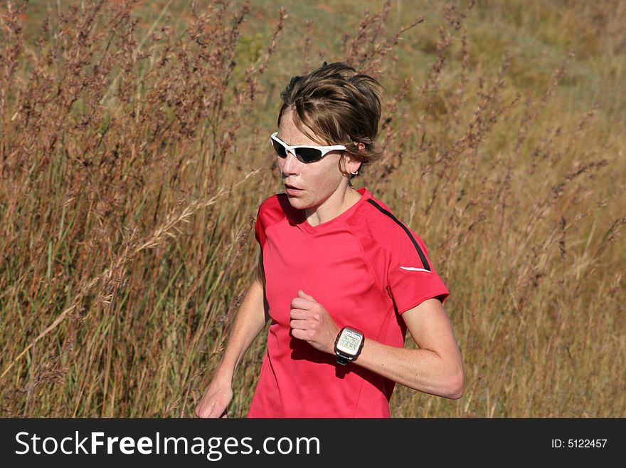 Female athlete in red running for training.