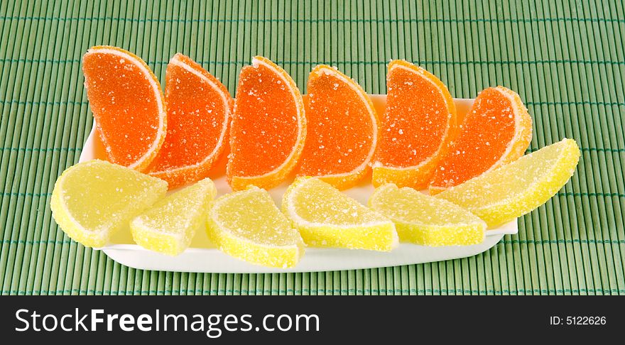 Fruit jellies lemon and orange lobules on a saucer