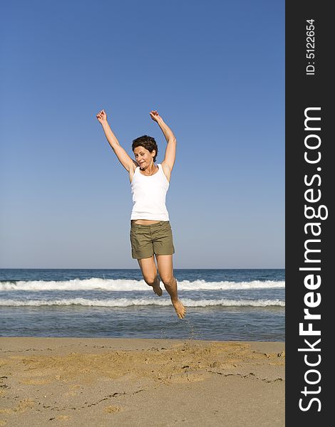 Young girl jumping on the beach