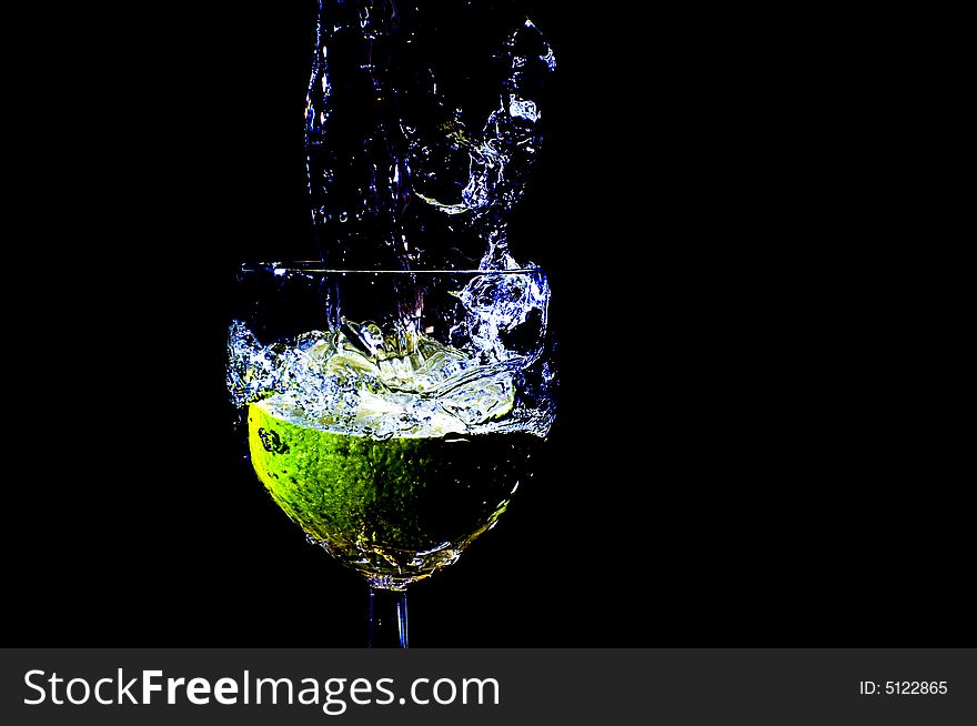 A peace of lemon falling in a glas with water. A peace of lemon falling in a glas with water