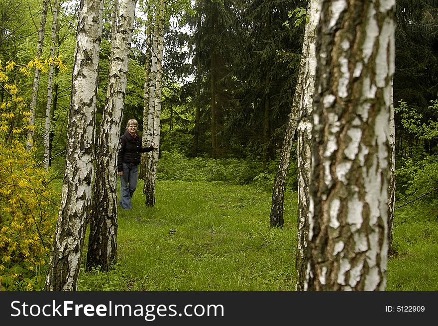 The beautiful girl relaxs in a birchwood. Birch is out of focus. The beautiful girl relaxs in a birchwood. Birch is out of focus.