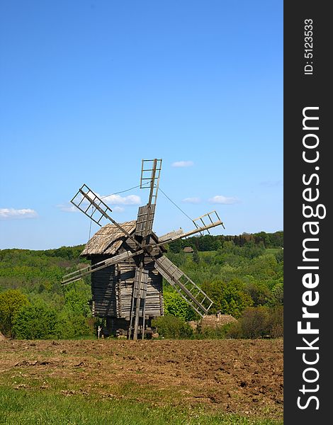 Windmill with fresh green grass and clear blue sky
