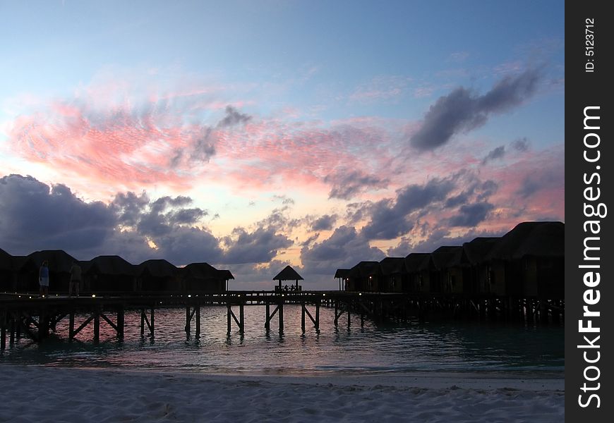 In this sunset you can see pink and dark clouds around maldivian overwaters. In this sunset you can see pink and dark clouds around maldivian overwaters