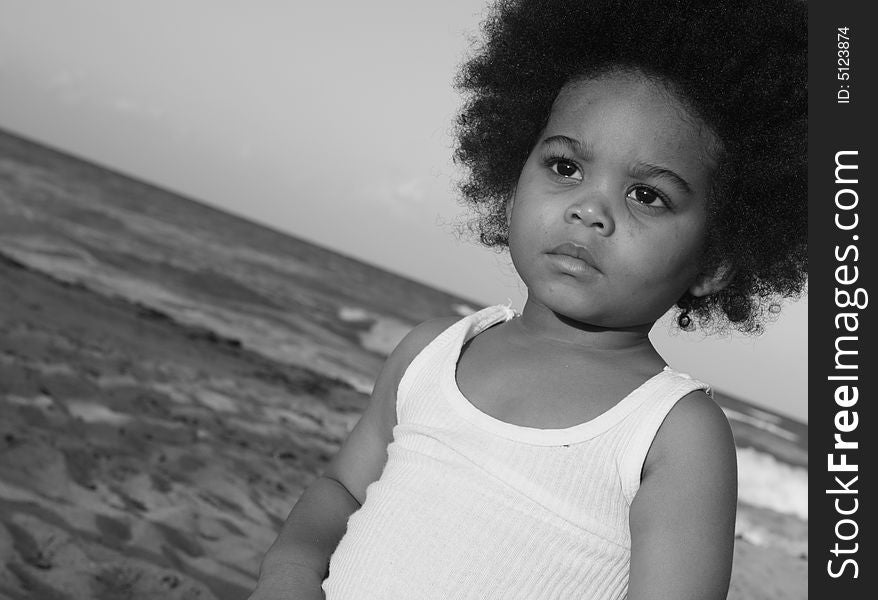 Black and white image of a young boy at the beach