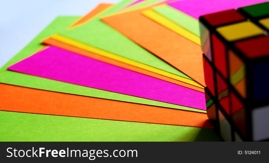 Papers and rubiks cube looks very colorful. Papers and rubiks cube looks very colorful