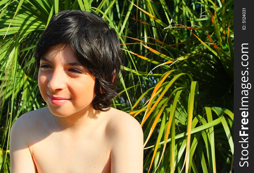 Shirtless Child with green palm trees in background. Shirtless Child with green palm trees in background.