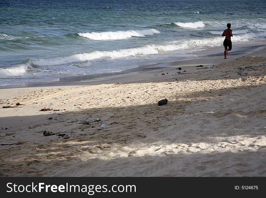 Man jogging alone on a dirty beach