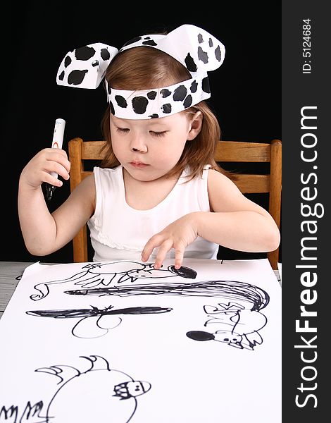 The small girl with dalmatian mask sketches the dog
