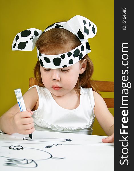 The small girl with dalmatian mask sketches the dog