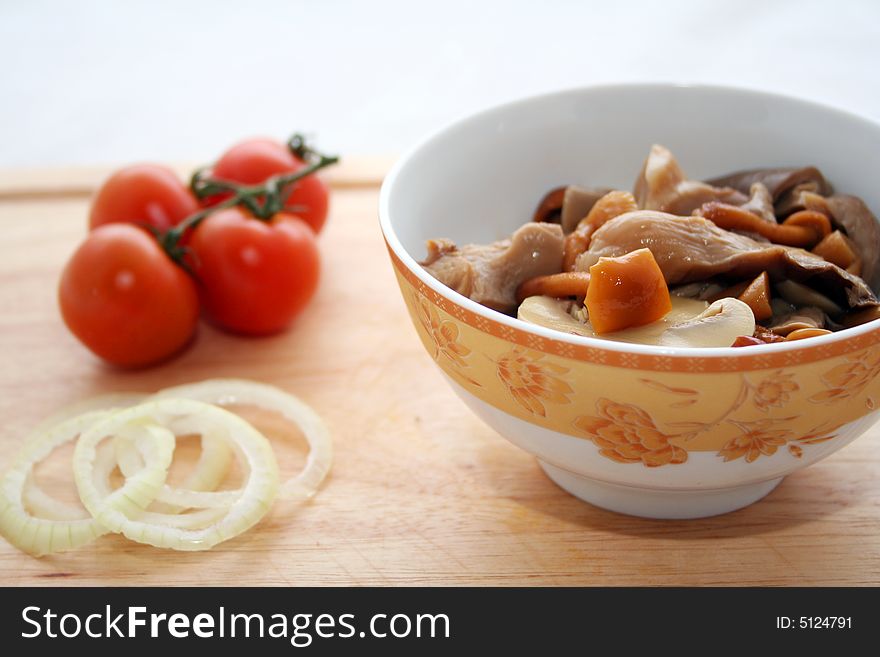 A salad of mixed mushrooms with onions and tomatoes