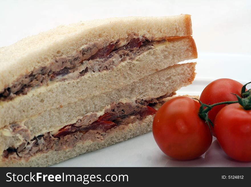 Two sandwiches filled with fish and some tomatoes