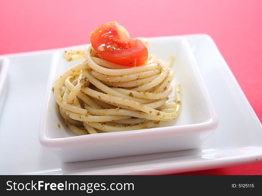 A meal Pasta and Pesto with a tomate