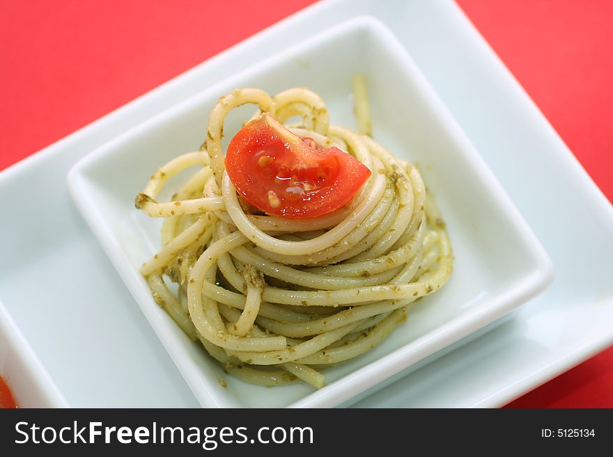 Pasta and Pesto with a piece of a tomato