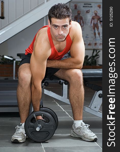 A shot of a male weightlifter doing a bicep curl with a barbell. A shot of a male weightlifter doing a bicep curl with a barbell.