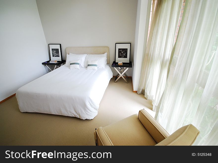 Comfortable bedroom with white covers on bed.