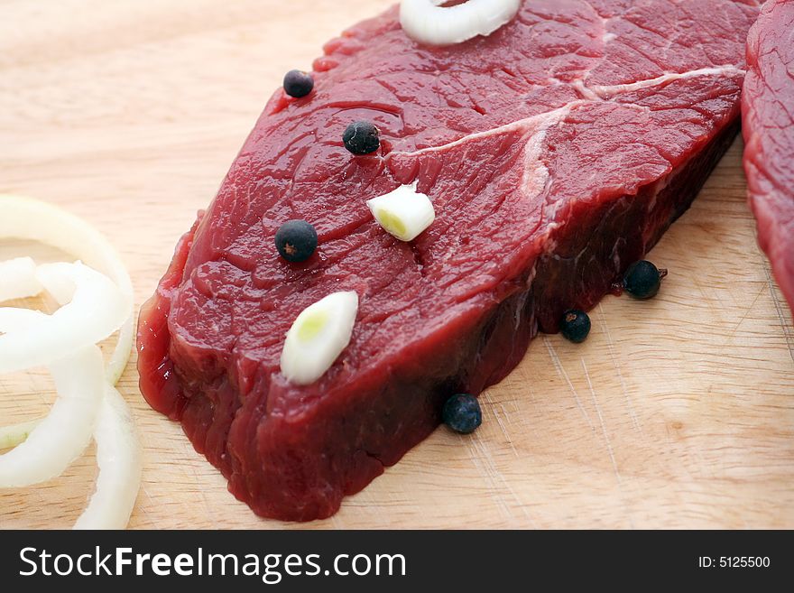 Two fresh and raw beef steaks with spices. Two fresh and raw beef steaks with spices