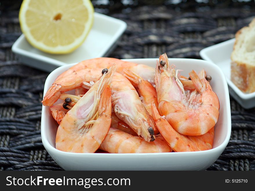 Some big prawns with some bread and a piece of lemon