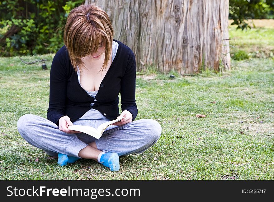 Young woman portrait reading in the park. Young woman portrait reading in the park.