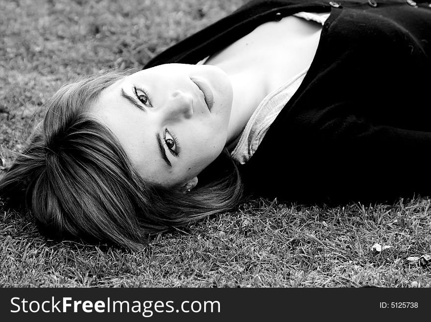 Laying woman staring at camera, black and white.