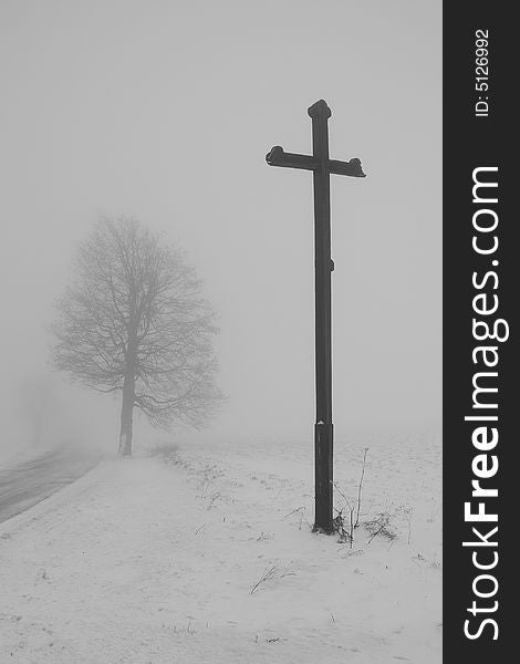 The cross and  tree by the way in winter fog. The cross and  tree by the way in winter fog.