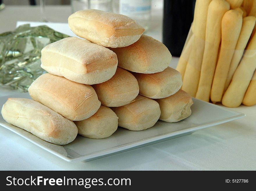Bread and breadsticks on a white plate. Bread and breadsticks on a white plate