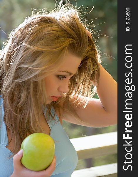 Girl with apple on sunset