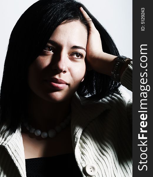 A high-key portrait about an attractive lady with black hair who is looking at something, she is wishing something and she has a charming look. She is wearing a white coat, a black dress and a white necklace. A high-key portrait about an attractive lady with black hair who is looking at something, she is wishing something and she has a charming look. She is wearing a white coat, a black dress and a white necklace.