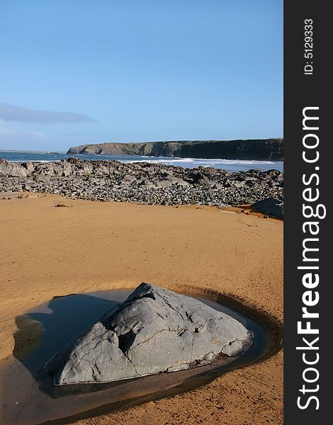 A  golden sandy beach in ballybunion county kerry ireland with a rock pool