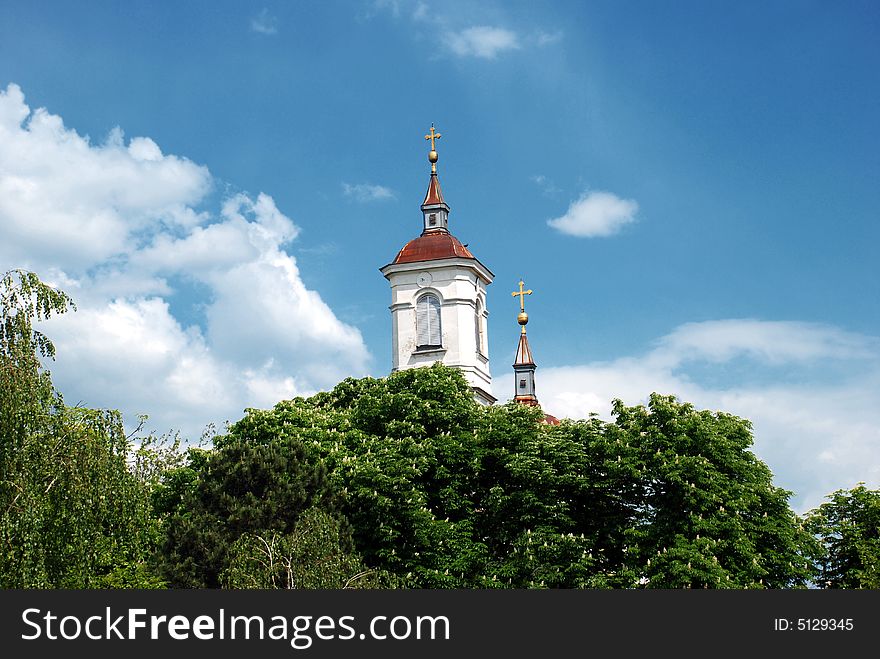 Orthodox church top over blue sky hidden in leaves. Orthodox church top over blue sky hidden in leaves