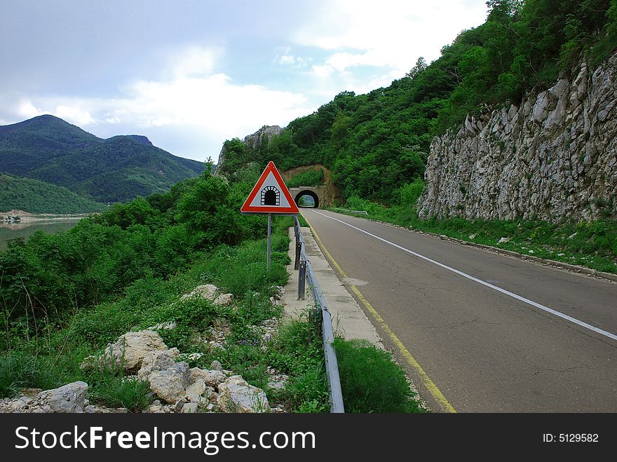 Tunnel in mountain, road and traffic sign. Tunnel in mountain, road and traffic sign