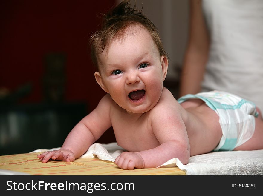 Small baby girl lying prone and smiling