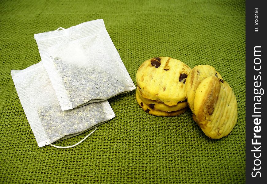 Cookies and tea bags, green background