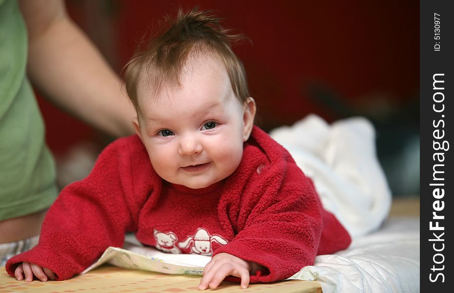 Small baby girl lying prone and smiling