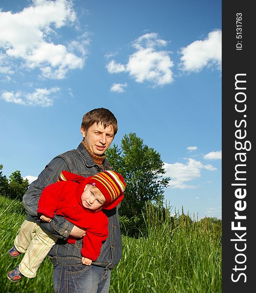 Father holds small daughter on a background of the nature