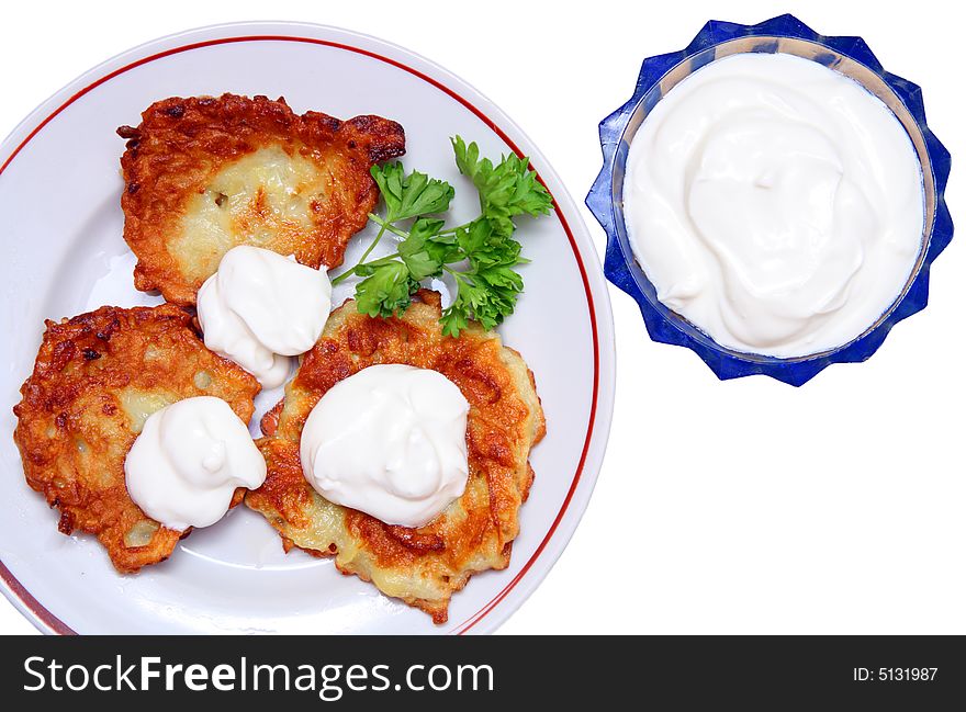 Potato pancakes on plate with sour cream isolated on white. Potato pancakes on plate with sour cream isolated on white