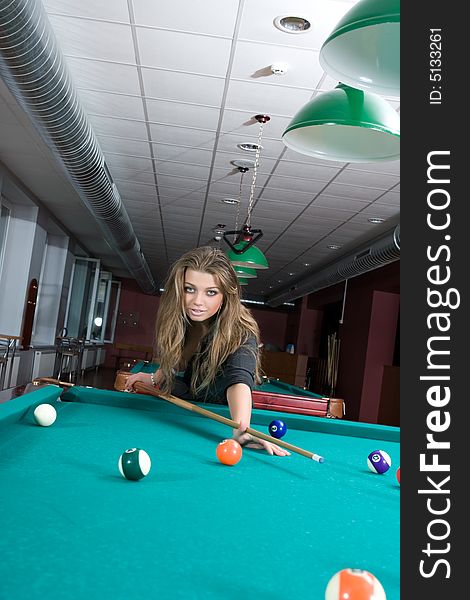 Young girl in short skirt playing snooker