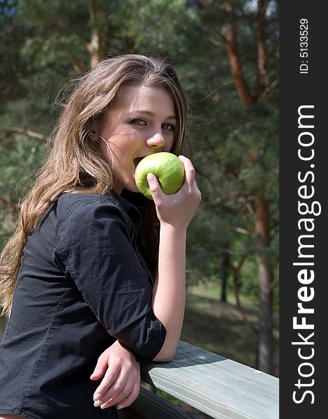 Young girl with apple on forest background