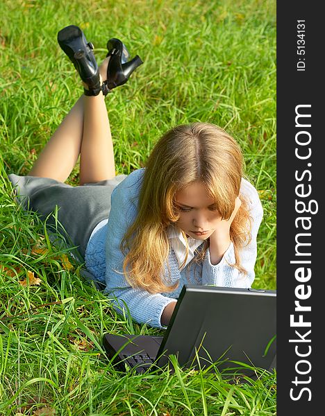 Businesswoman lying on green grass with notebook. Businesswoman lying on green grass with notebook