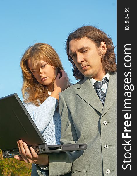 Business couple discussing something with notebook in hands