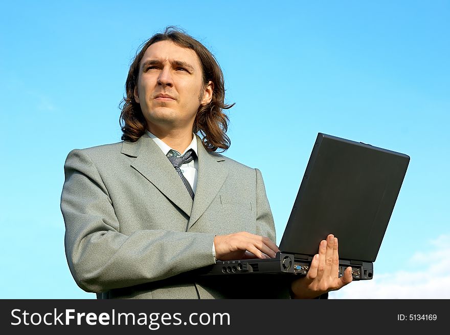 Businessman with notebook under the skies