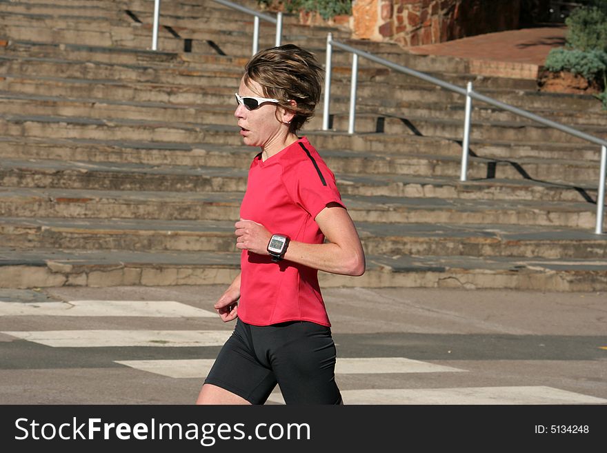 Female athlete in red running for training.