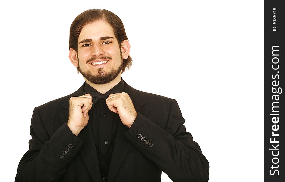 Shot of isolated young man wearing formal suit and bow tie. he is holding his bow tie. Shot of isolated young man wearing formal suit and bow tie. he is holding his bow tie