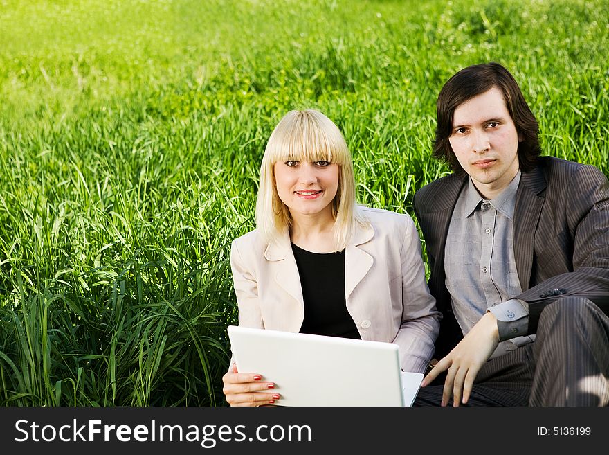 Boy and girl dressed for business with laptop on the grass. Boy and girl dressed for business with laptop on the grass