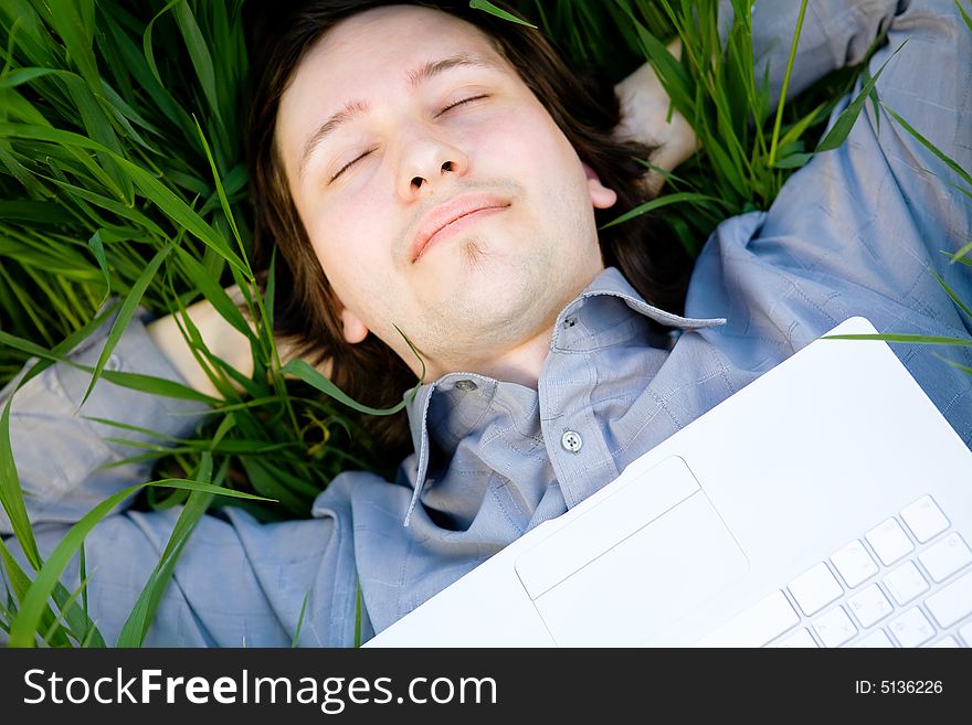 Businessman rest on the grass with laptop. Businessman rest on the grass with laptop